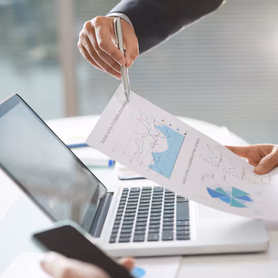 Analisi di un documento con grafici accanto a un laptop